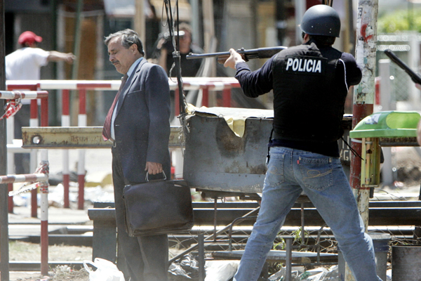 A man is caught between Argentine police and rioters during clashes in Buenos Aires, Argentina, November 1, 2005. Reuters